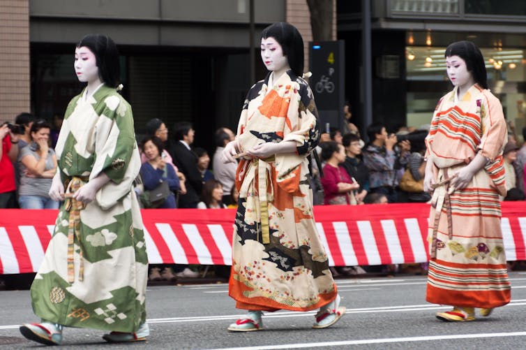 Three women in historic Japanese dress and makeup.