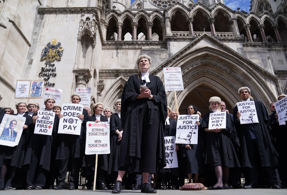 A group of barristers in wigs and gowns carrying strike signs