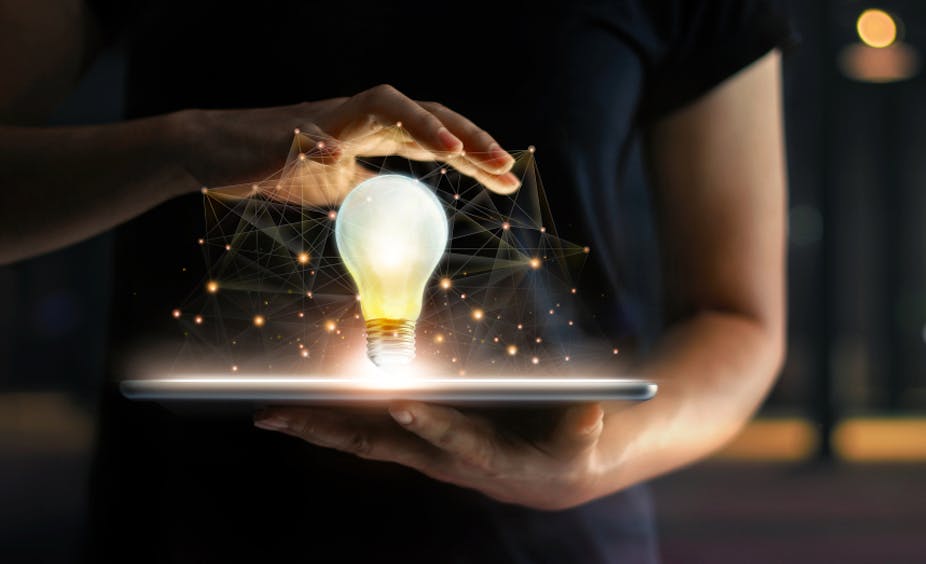 Mains tenant une tablette et une ampoule lumineuse avec connexion réseau globale à l'écran