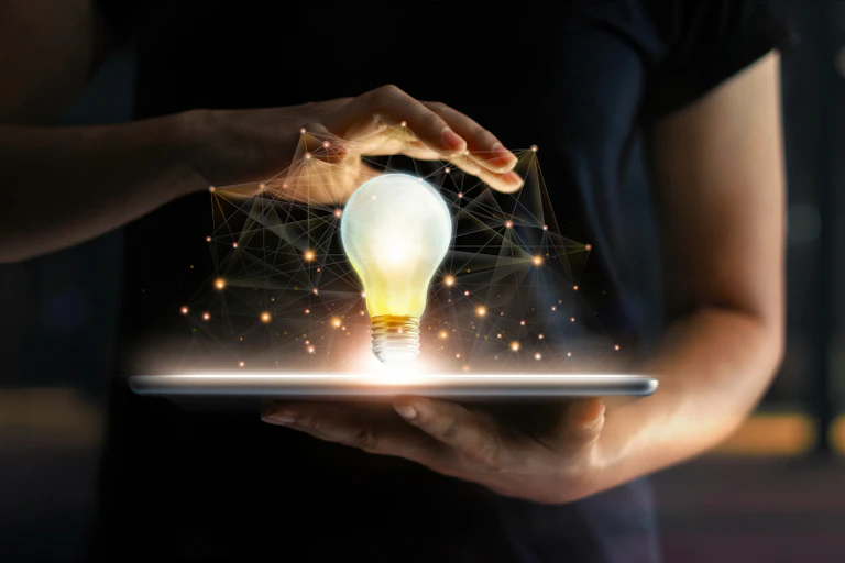Mains tenant une tablette et une ampoule lumineuse avec connexion réseau globale à l'écran