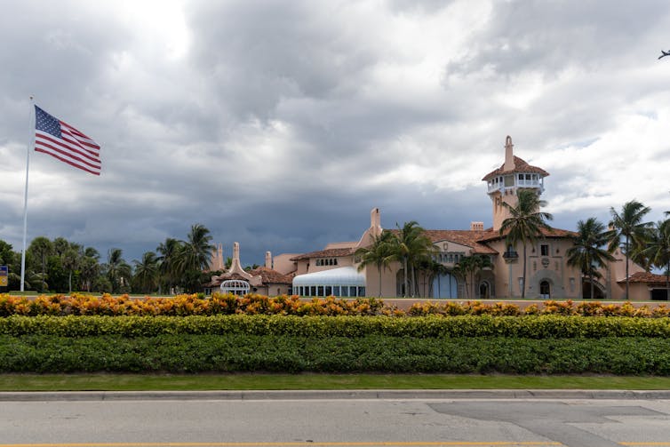 A large brown residential appearing building is shown on a day with dark clouds.