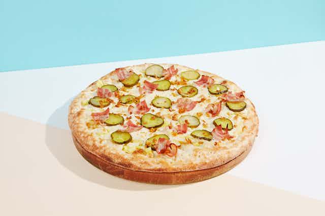 Pizza with bacon and pickles as toppings.