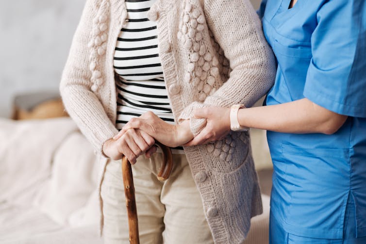 health worker helps older woman