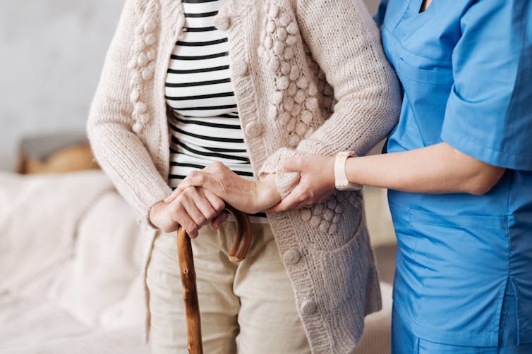 health worker helps older woman