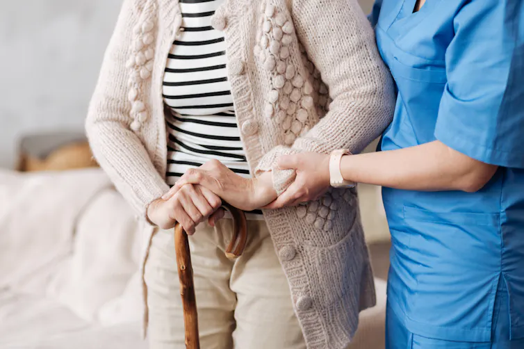 health worker helps older woman