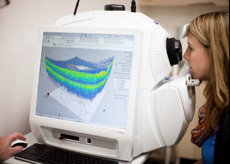 A person having a retinal scan taken by an optical coherence tomography device.