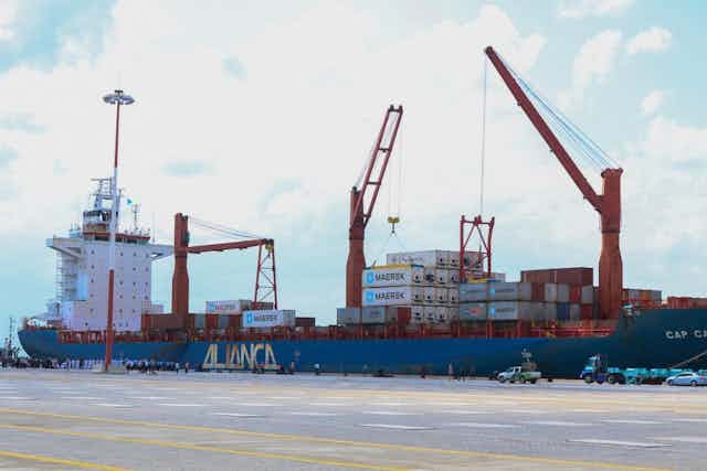 Cranes offloading containers from a ship.