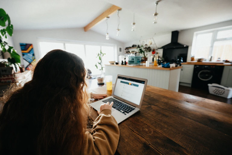 Child using laptop at kitchen table