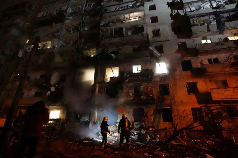 Two firefighters in front of a burning building