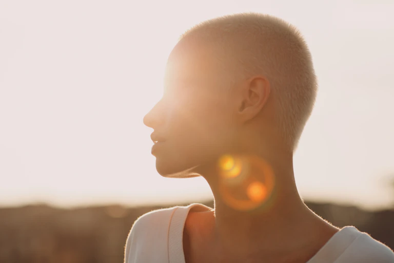 woman's shoulders-up silhouette against sun