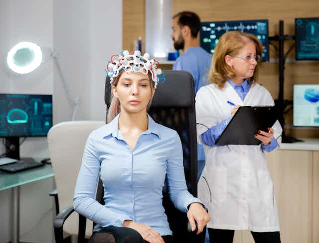 A woman wearing an EEG brain scanner