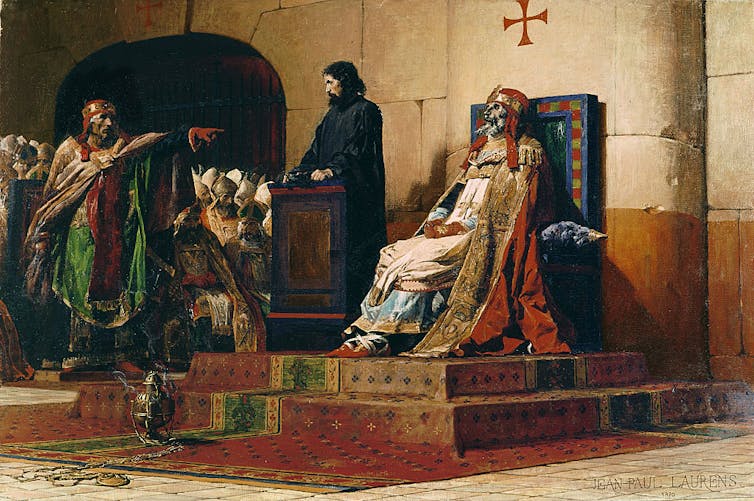A painting shows men in robes pointing to a skeleton dressed up and sitting on a throne.