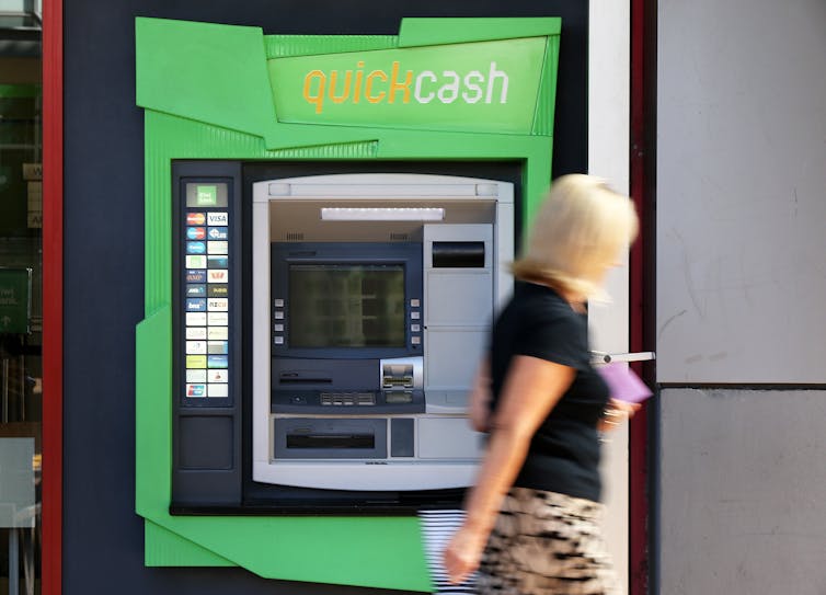 Woman walking past an ATM