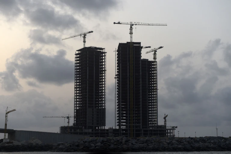 Three tall buildings under construction.