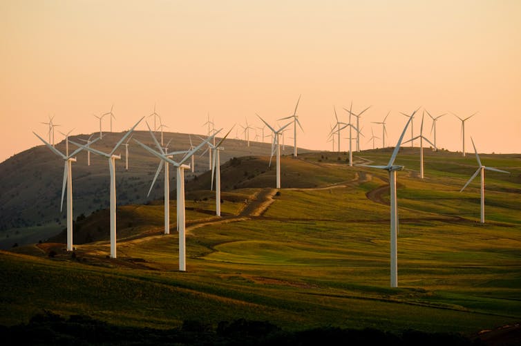 Wind turbines on a hill at sunset