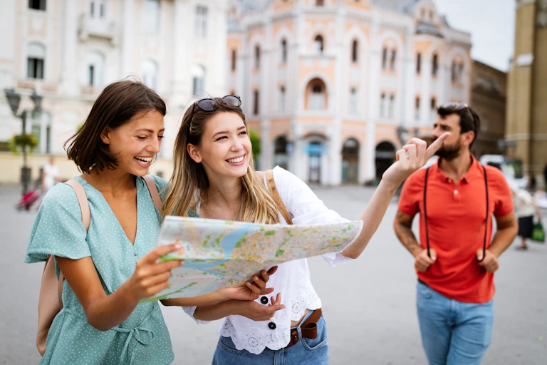 Young women looking at map in city