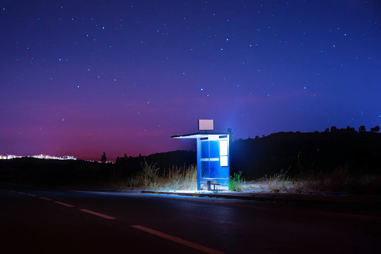 Una parada de autobús iluminada en la oscuridad.