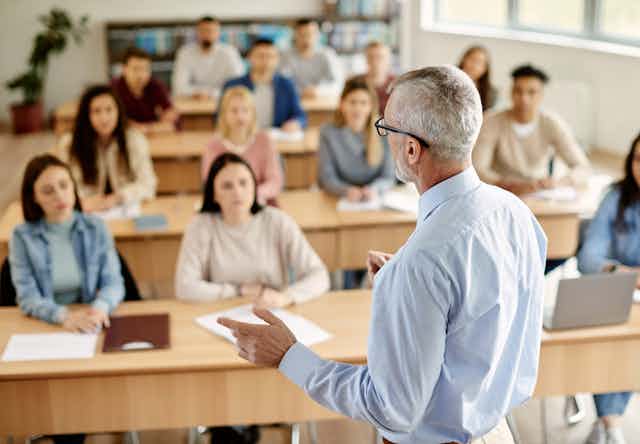 A man speaks to students in a classroom.