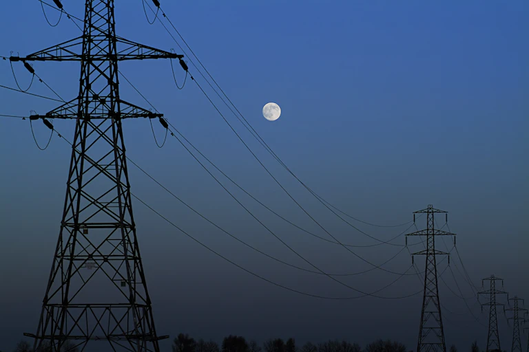 Electricity pylons at night with moon