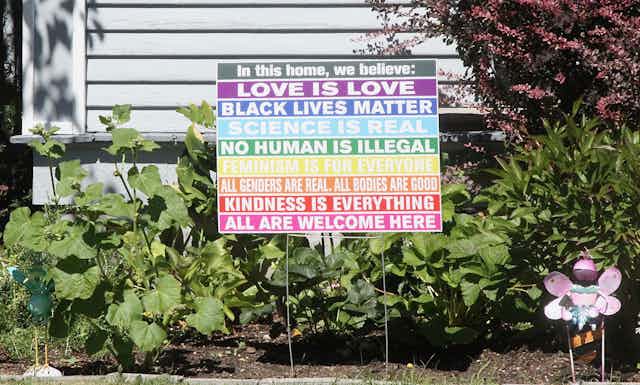 A sign listing eight virtues, including Black Lives Matter and No Human is Illegal.