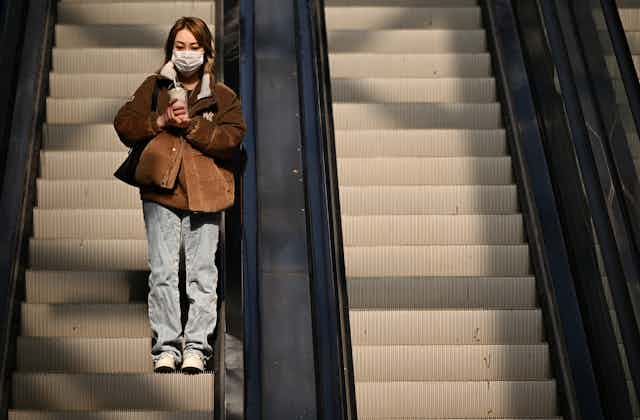 Woman on an escalator.