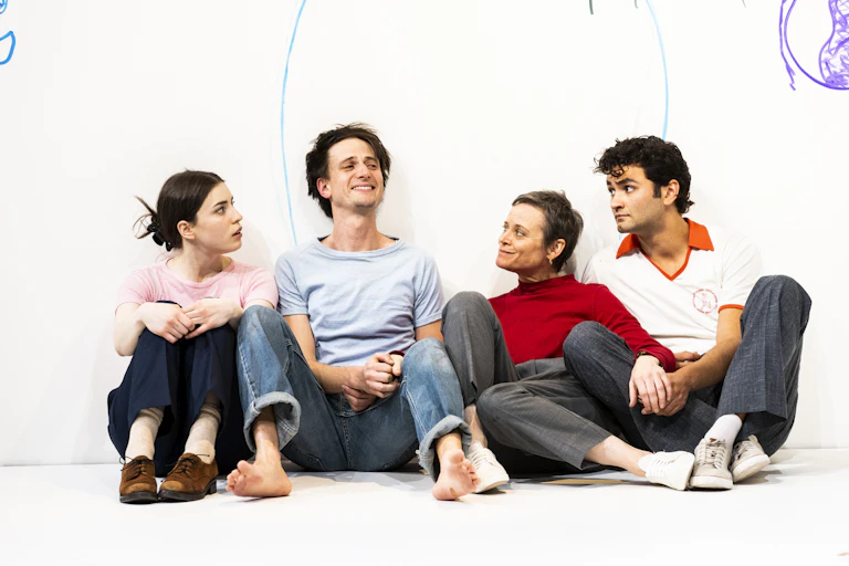 Four people sit on a white stage