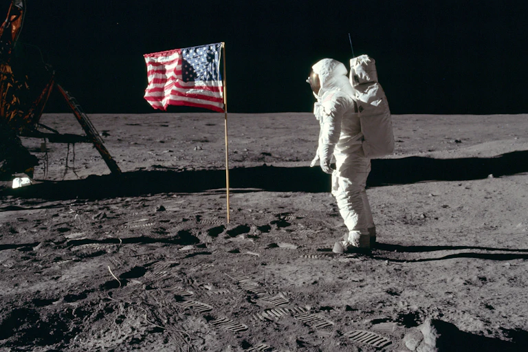 Un astronaute en combinaison spatiale salue le drapeau américain sur la Lune.