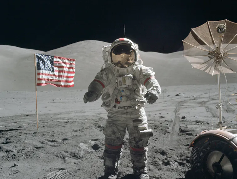Eugene Cernan sur la Lune en combinaison devant le drapeau américain