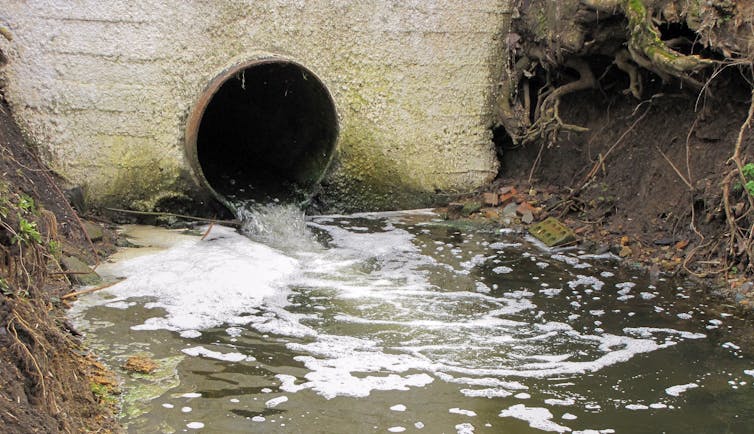 A sewer outflow discharging water into a river.