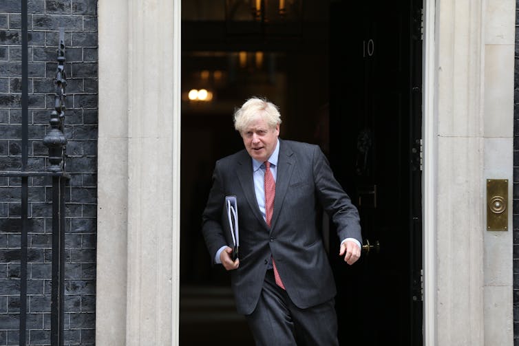Boris Johnson walking out of Number 10 Downing Street with a folder under his arm