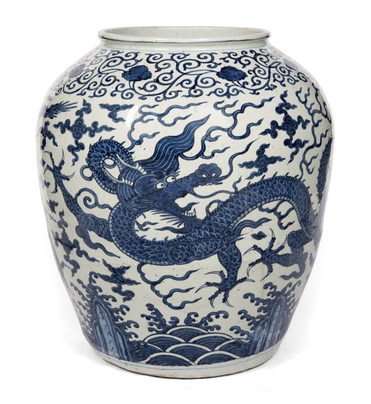 A blue and white Ming dynasty jar decorated with claw-footed dragons.