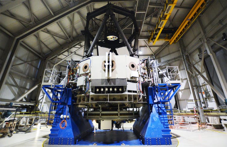 A large, circular device in a hangar space