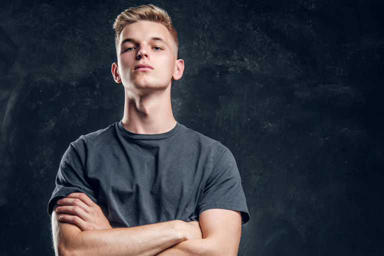 A young man looking arrogant, with crossed arms.