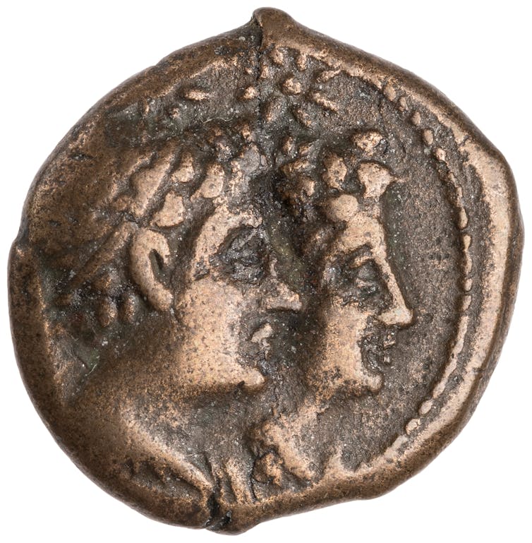 A bronze coin showing two engraved faces.
