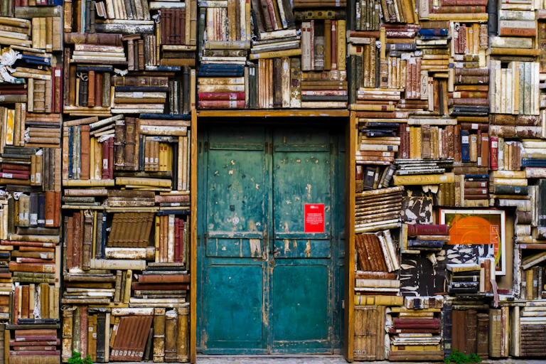A turquoise door set in a wall full of books