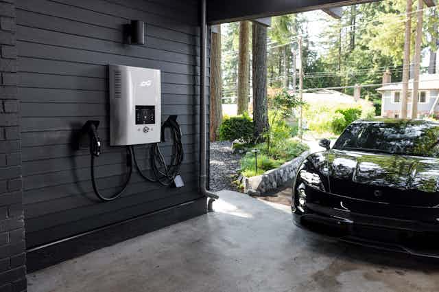 car at entrance to home garage with electric charging system