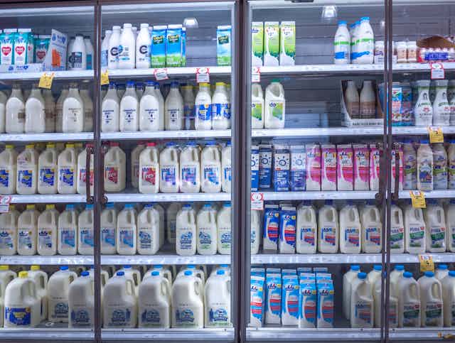 bottles of milk in fridge at supermarket