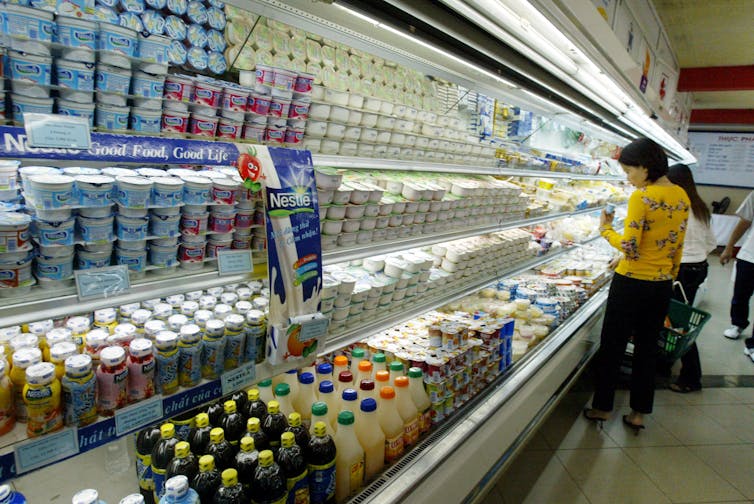 Woman looks at milk in supermarket in Vietnam