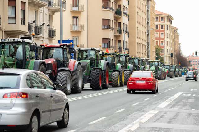 Fila de tractores en una calzada en la ciudad.