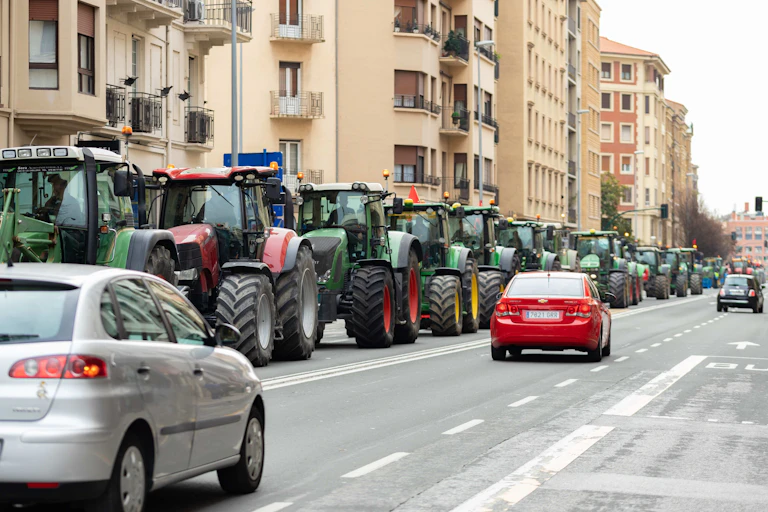 Fila de tractores en una calzada en la ciudad.