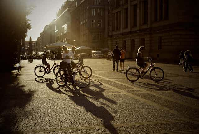 Des cyclistes se préparent en ville, dans une rue sans voiture