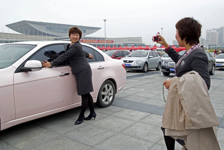 Vendedores de la provincia de Anhui, China, posan para fotografías frente a un sedán rosa, un premio al mejor equipo de ventas, durante la Conferencia de Liderazgo de Mary Kay China el 20 de febrero de 2011, en Xiamen, provincia de Fujian, China.