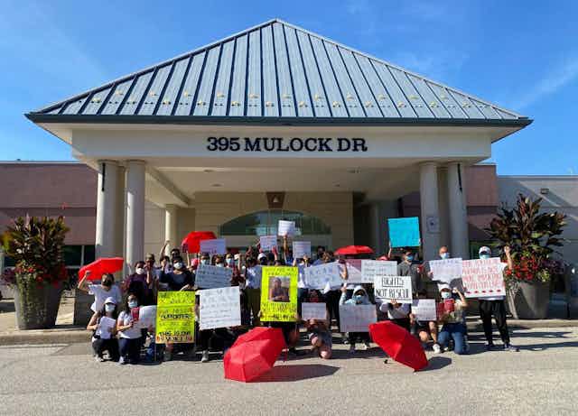 Asian migrant massage workers and allies rally against Newmarket's discriminatory licensing crackdown on their workplaces in front of Newmarket Municipal Offices.