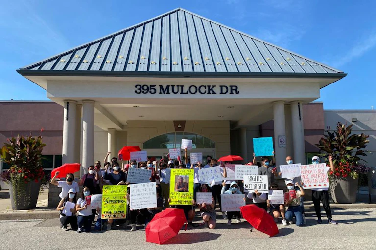 Asian migrant massage workers and allies rally against Newmarket's discriminatory licensing crackdown on their workplaces in front of Newmarket Municipal Offices.