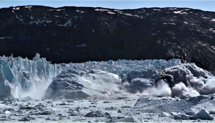 Um grande iceberg se desprende de uma geleira.