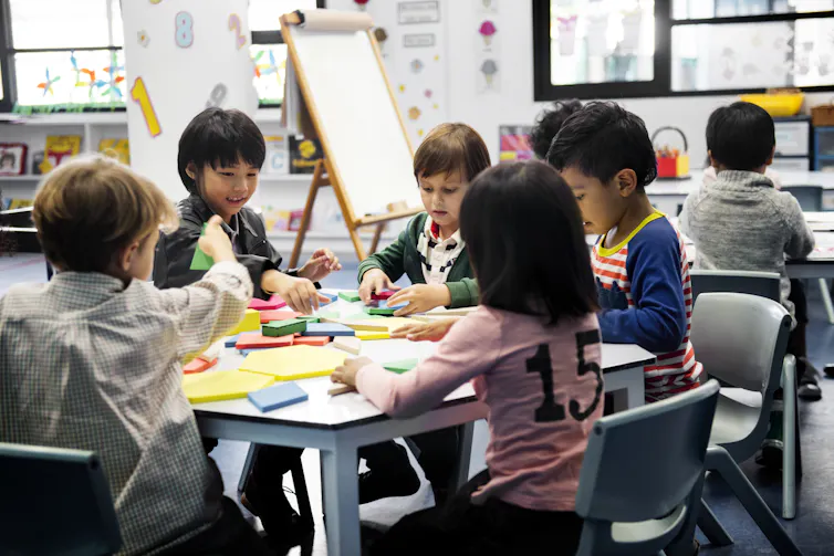 Young students seen sitting at a table.