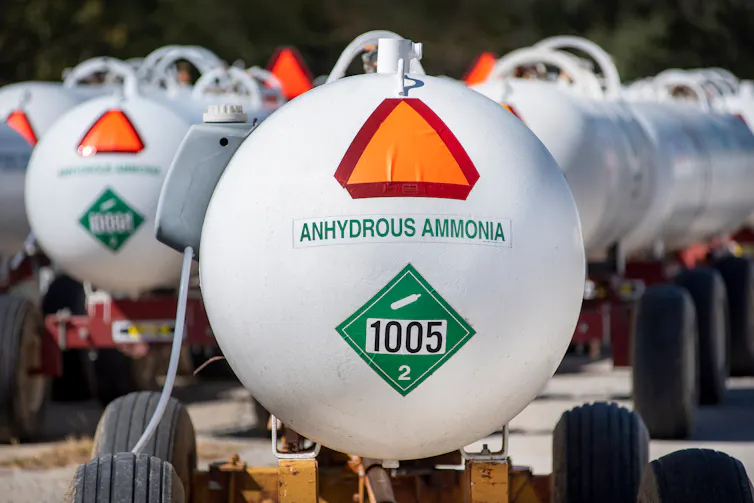 A round, white tank that says 'anhydrous ammonia' on the front