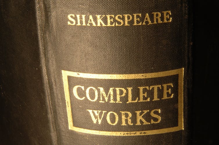 A closeup on the spine of a book of the complete works of Shakespeare.