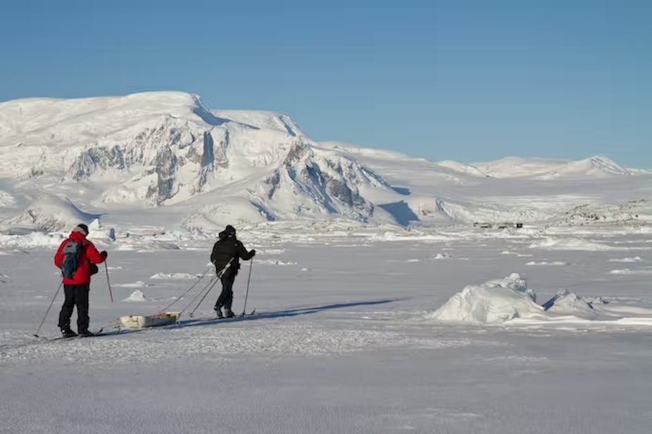 Dua penjelajah berjalan melintasi salju di Antartika