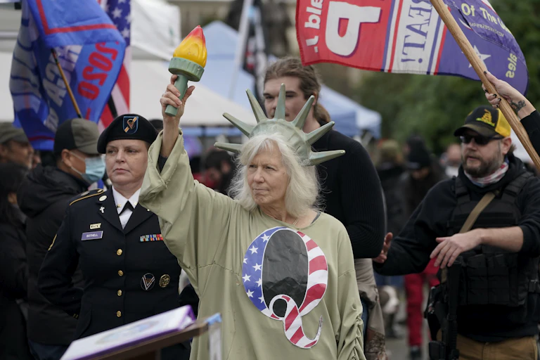 a woman dresses as the statue of liberty wearing a tshirt with the letter q on it